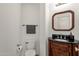 Small bathroom with dark vanity, black countertop, and a framed mirror at 7893 S Stephanie Ln, Tempe, AZ 85284