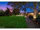 Spacious backyard with lush green lawn, brick pathway, mature trees, and a view of the pool area at 8031 N 14Th Ave, Phoenix, AZ 85021