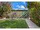 Backyard with a well manicured lawn, mature tree and storage shed on a cement walkway at 8031 N 14Th Ave, Phoenix, AZ 85021