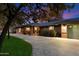 Inviting brick home featuring mature landscaping, manicured lawn, and a cozy, covered entry at dusk at 8031 N 14Th Ave, Phoenix, AZ 85021