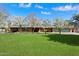 Charming red brick home featuring a lush green lawn and flowering trees under a bright blue, sunny sky at 8031 N 14Th Ave, Phoenix, AZ 85021