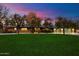 Charming red brick home with a lush green lawn and flowering trees set against a dramatic dusk sky at 8031 N 14Th Ave, Phoenix, AZ 85021