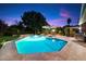 Backyard pool with an umbrella-covered table, lights, and green grass at 8031 N 14Th Ave, Phoenix, AZ 85021