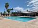 Community pool with lounge chairs and palm trees at 916 Mineshaft Dr # 916, Apache Junction, AZ 85119