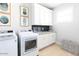 Laundry room with white cabinets, washer, dryer, and countertop at 10018 E Hillside Dr, Scottsdale, AZ 85255