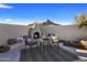 Cozy outdoor fireplace and seating area with mountain backdrop at 10452 E Quartz Rock Rd, Scottsdale, AZ 85255