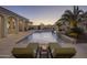 Luxury pool with waterfall feature, inviting lounge chairs, and stunning sunset views at 10452 E Quartz Rock Rd, Scottsdale, AZ 85255