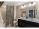 Double vanity bathroom with a striped shower curtain and dark cabinets at 10538 E Sheffield Dr, Mesa, AZ 85212