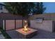 Modern outdoor kitchen with built-in grill and fire pit at 10538 E Sheffield Dr, Mesa, AZ 85212