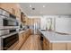 Open kitchen with stainless steel appliances and light wood cabinets at 1082 W Aspen Ave, Gilbert, AZ 85233