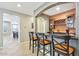 Home bar with granite countertop, wine rack, and orange-painted accent wall at 12736 W Auburn Dr, Peoria, AZ 85383