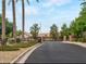 Gated community entrance with lush landscaping and palm trees at 12762 W Vista Paseo Dr, Litchfield Park, AZ 85340