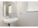 Clean and modern bathroom with a pedestal sink and mirror at 14518 W Port Royale Ln, Surprise, AZ 85379