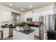 Modern kitchen with white cabinets, granite countertops, and stainless steel appliances at 14518 W Port Royale Ln, Surprise, AZ 85379