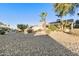 Sunny backyard with gravel landscaping, desert plants, and a partially covered patio at 1621 E Firestone Dr, Chandler, AZ 85249