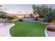 Lush backyard with artificial turf, decorative landscaping, and comfortable seating area at 1684 E Coconino Dr, Chandler, AZ 85249