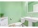 Small bathroom with mint green walls, pedestal sink, and white toilet at 1684 E Coconino Dr, Chandler, AZ 85249