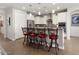 Modern kitchen with white cabinets, a large island, and red barstools at 20515 N 274Th Ln, Buckeye, AZ 85396