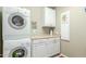 Bright laundry room, featuring stackable washer and dryer, and ample cabinets at 2144 S Yellow Wood Ave, Mesa, AZ 85209