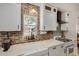 Bright kitchen boasts white cabinets, farmhouse sink, and a brick accent wall at 2218 N 8Th St, Phoenix, AZ 85006