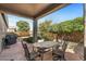 Covered patio with seating area, grill, and lush landscaping at 22205 N Cochise Ln, Sun City West, AZ 85375