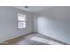 Simple bedroom with large window and wood-look flooring at 33868 N Mercedes Dr, San Tan Valley, AZ 85144