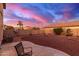 Backyard with gravel and a patio area, offering a sunset view at 403 S 228Th Ln, Buckeye, AZ 85326