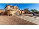 Two-story house with tan exterior, two-car garage, and desert landscaping at 403 S 228Th Ln, Buckeye, AZ 85326