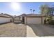 Front view of a tan house with a two-car garage and desert landscaping at 4149 W Park Ave, Chandler, AZ 85226