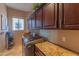 Bright laundry room with granite counters and ample cabinetry at 4410 E Robin Ln, Phoenix, AZ 85050