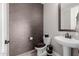 Stylish powder room featuring stone accent wall and pedestal sink at 4813 S Quantum Way, Mesa, AZ 85212