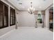 Elegant dining room with large windows, plantation shutters, and a modern chandelier at 4813 S Quantum Way, Mesa, AZ 85212