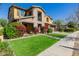 A two-story home with a stone and stucco exterior and a well-manicured lawn with flowerbeds at 4813 S Quantum Way, Mesa, AZ 85212