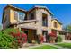 Close up of a two-story home with a stone and stucco exterior and vibrant flowerbeds at 4813 S Quantum Way, Mesa, AZ 85212