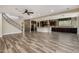 Open living area offers wood-look tile floors and an easy flow into a modern kitchen with stone accents at 4813 S Quantum Way, Mesa, AZ 85212