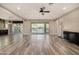 Open living area with wood-look tile flooring, large sliding glass doors to backyard, and modern ceiling fan at 4813 S Quantum Way, Mesa, AZ 85212