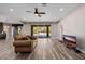 Spacious living room with tile floors, a ceiling fan, and a sliding glass doors overlooking the pool at 4813 S Quantum Way, Mesa, AZ 85212