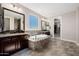 Luxurious main bathroom boasting a soaking tub, dual sinks, and a bright window with an outdoor view at 4813 S Quantum Way, Mesa, AZ 85212