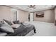 Spacious main bedroom featuring plush carpeting, a ceiling fan, and a large television at 4813 S Quantum Way, Mesa, AZ 85212