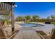 Inviting pool and patio area perfect for entertaining and relaxation, complete with pergola and lush landscaping at 4813 S Quantum Way, Mesa, AZ 85212