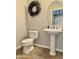 Clean bathroom with pedestal sink, toilet, and decorative wreath at 4905 W Magellan Dr, New River, AZ 85087