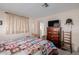 Bedroom featuring a queen bed, dresser and large window with curtains at 5646 E Player Pl, Mesa, AZ 85215