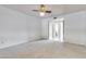 Bright bedroom with neutral carpeting and ceiling fan, leading to the bathroom at 6026 W Juniper Ave, Glendale, AZ 85306