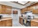 Kitchen with wood cabinets, stainless steel appliances, and adjacent laundry area at 6026 W Juniper Ave, Glendale, AZ 85306