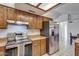 Kitchen boasts stainless steel range, refrigerator, and wood cabinetry at 6026 W Juniper Ave, Glendale, AZ 85306