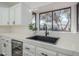 Modern kitchen with white cabinets, black sink, and a large window at 605 S 30Th Cir, Mesa, AZ 85204