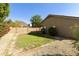 Landscaped backyard with grassy area, gravel, and brick border at 6602 W Prickly Pear Trl, Phoenix, AZ 85083