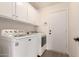 Laundry room with washer, dryer, and overhead cabinets at 6902 S 14Th Dr, Phoenix, AZ 85041