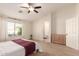 Main bedroom with carpeted floors, a ceiling fan, large window and ensuite bathroom at 6902 S 14Th Dr, Phoenix, AZ 85041