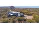 Aerial view of a home with a casita and garage, situated on a hillside with desert landscape at 7002 E Leisure Ln, Carefree, AZ 85377